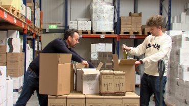 Vrijdag begon de verkoop van de Horeca Surprise Box. Ondernemer Huub van den Muijsenbergh zit met flessen die nu in boxen worden verpakt. Een deel van de opbrengst gaat naar de horeca.