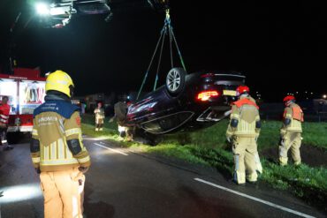 Een van de gecrashte auto's wordt uit de sloot getakeld.