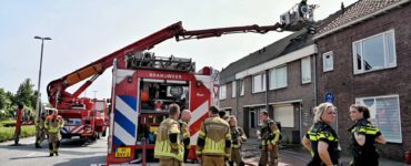 Brandweer die de zolderbrand blust