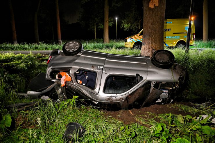 Man komt op zijn kop in sloot terecht, na botsing met boom